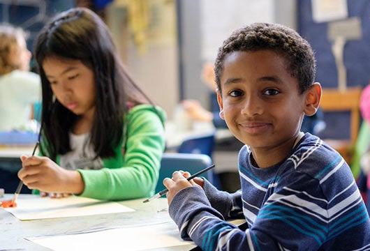 A young student looks at the camera and smiles for a photo